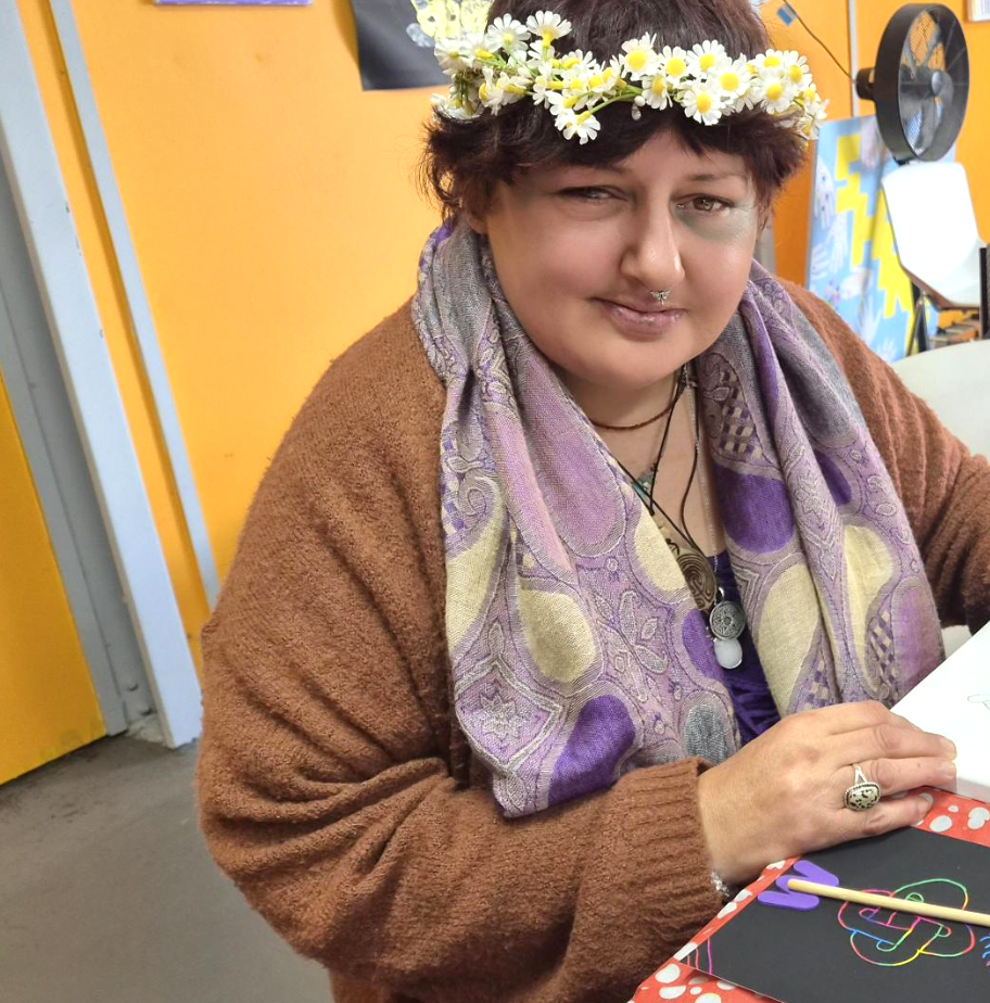 Kathleen wearing a daisy flower crown at a craft table